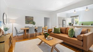 A modern living room with a sofa, coffee table, and dining area.