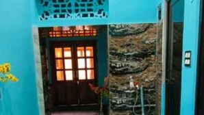 Un couloir doté d’un sol à motifs, une porte avec une fenêtre et un mur orné d’un décor en relief.