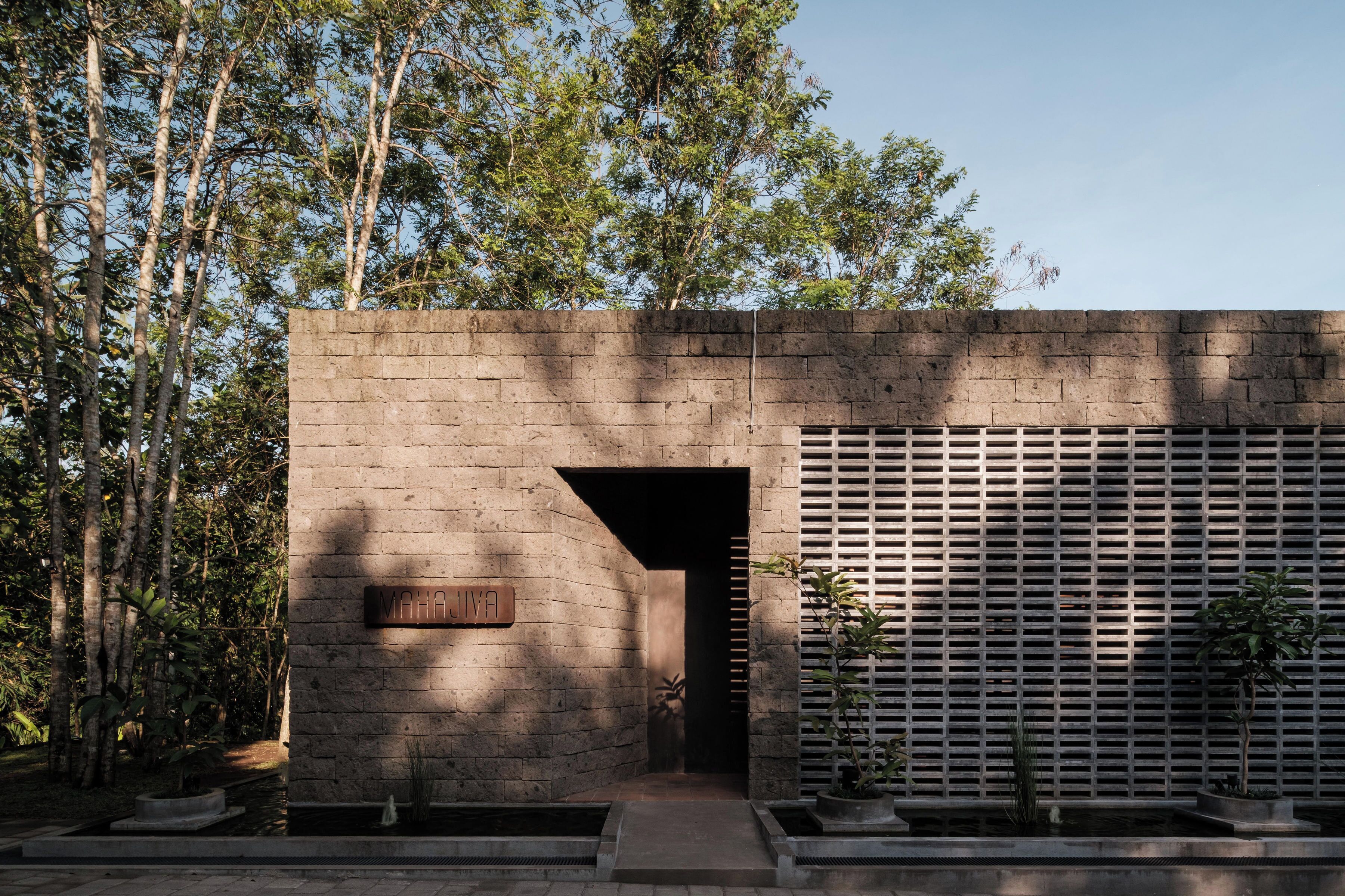 A modern building with a brick facade, a metal slatted wall, and a sign that reads "MAHAJIVA".