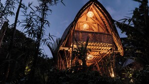 A wooden structure with a triangular roof, surrounded by dense foliage. - Mahajiva (Abiansemal)
