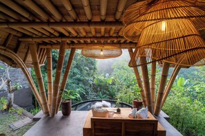 A bamboo structure with a table and chairs, surrounded by lush greenery. - Mahajiva (Abiansemal)