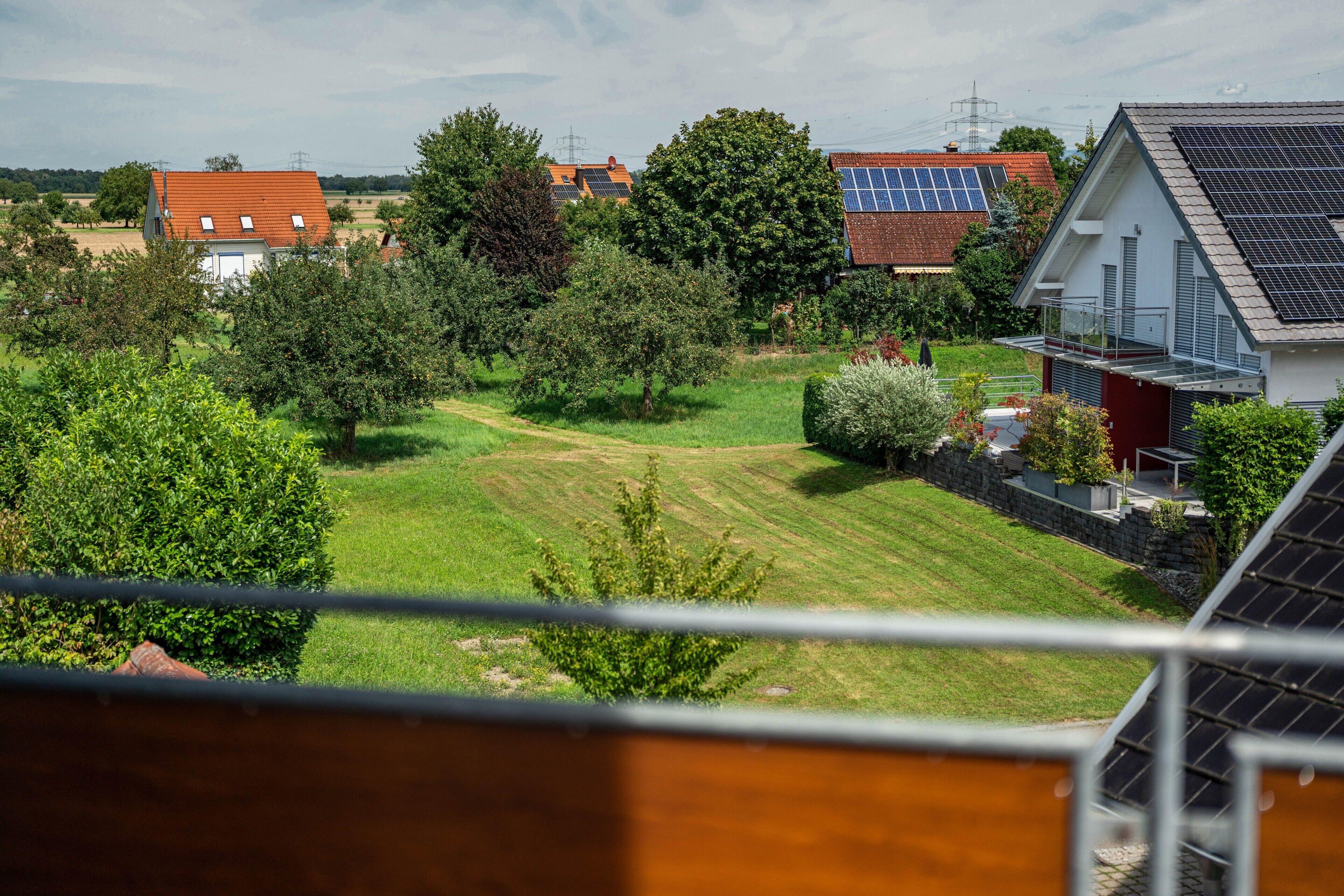 Un quartier résidentiel avec des maisons, des panneaux solaires et une pelouse bien entretenue.