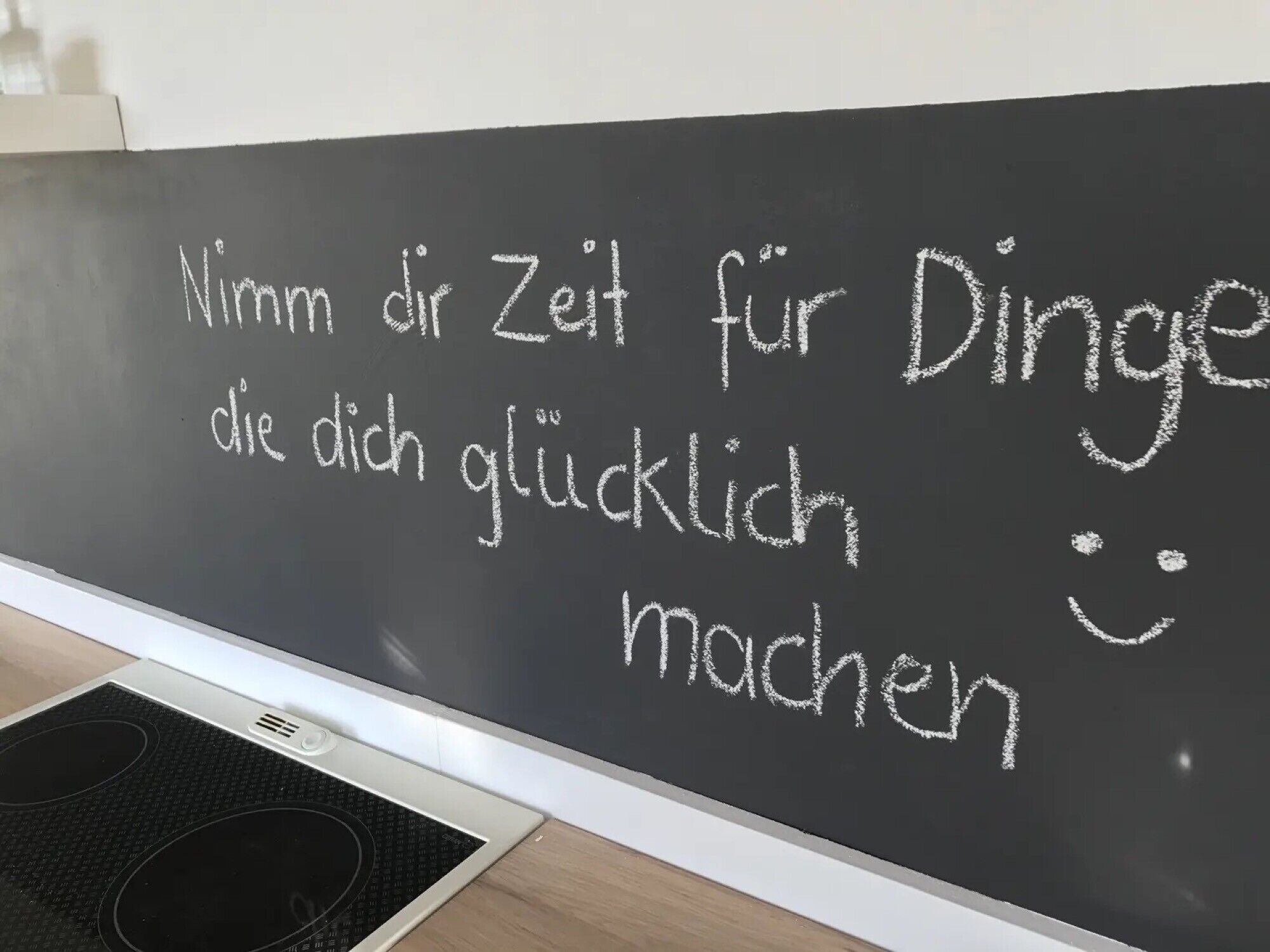 Eine Tafel mit deutschem Text und einem Smiley.