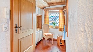Una puerta de madera, una silla de mimbre y una ventana con vistas.