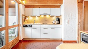 A compact kitchen with white cabinets, a sink, and a coffee maker.