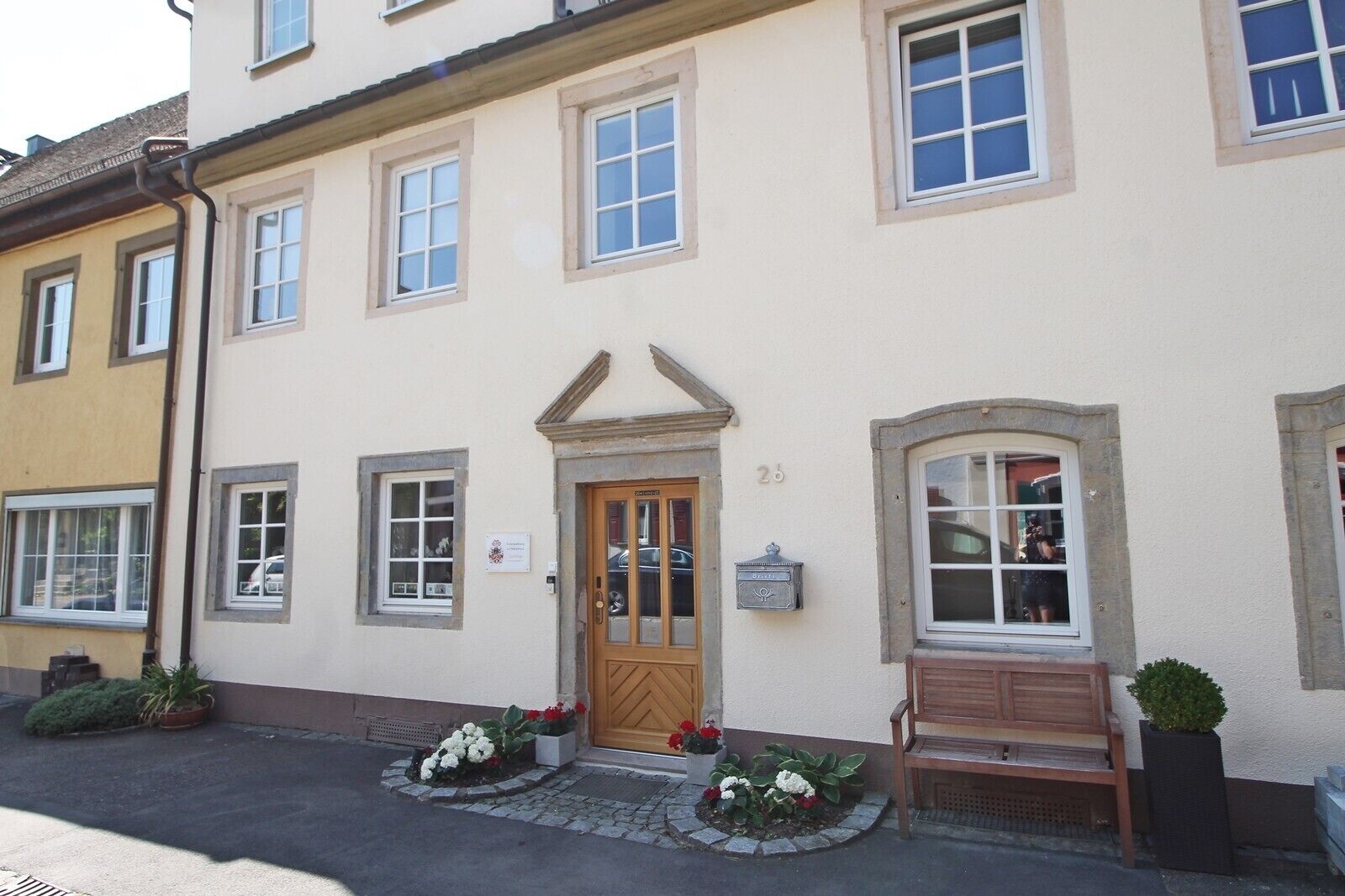 A building with a central entrance, multiple windows, and a mailbox.