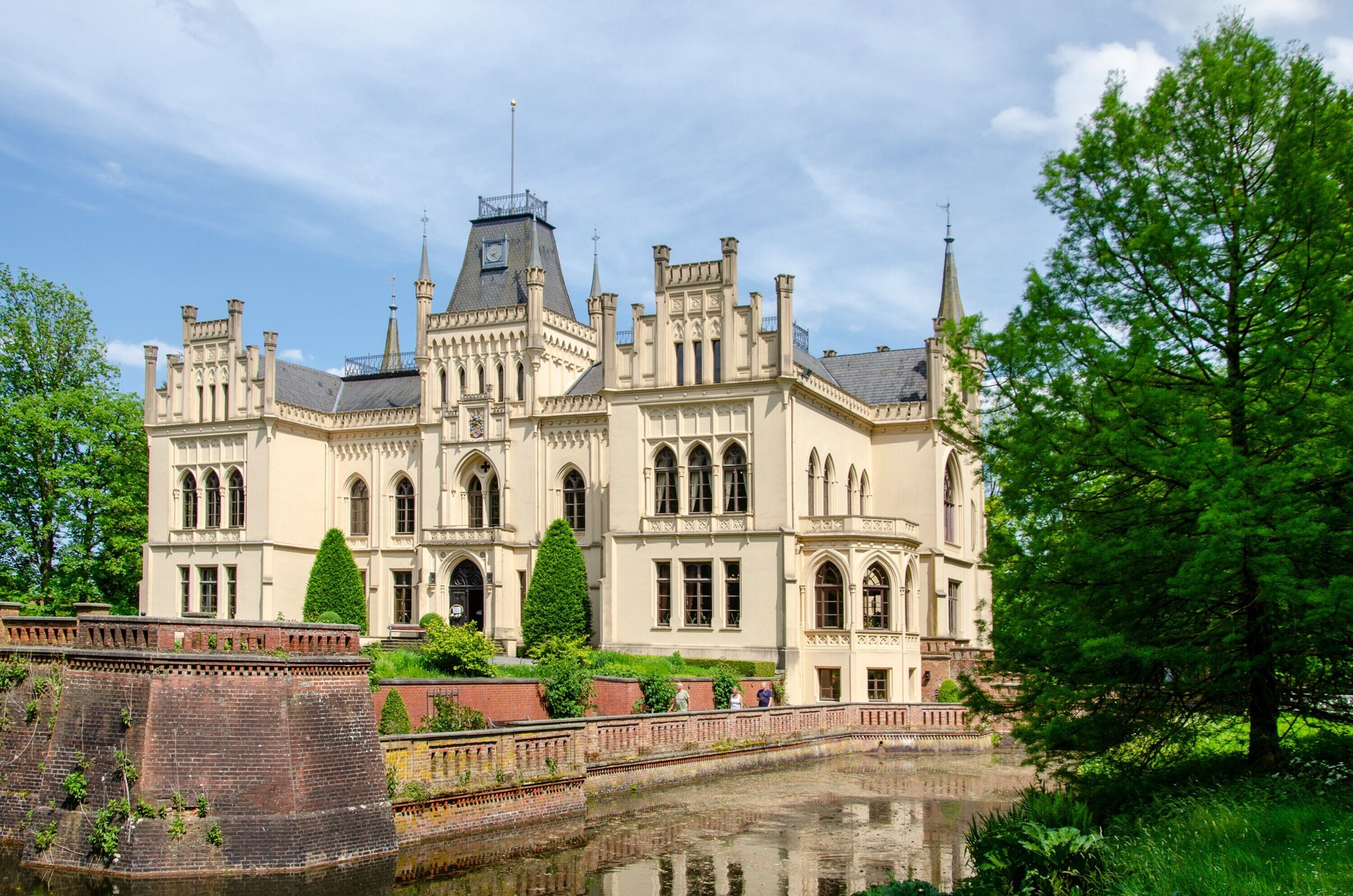 Un bâtiment historique à la façade symétrique, doté de fenêtres en arc et d’une tour centrale.