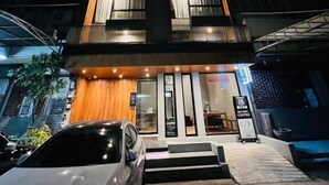 A modern building with a wooden facade, multiple balconies, and a sign for a coffee shop. - Woodstory Boutique Hotel (Bangkok)
