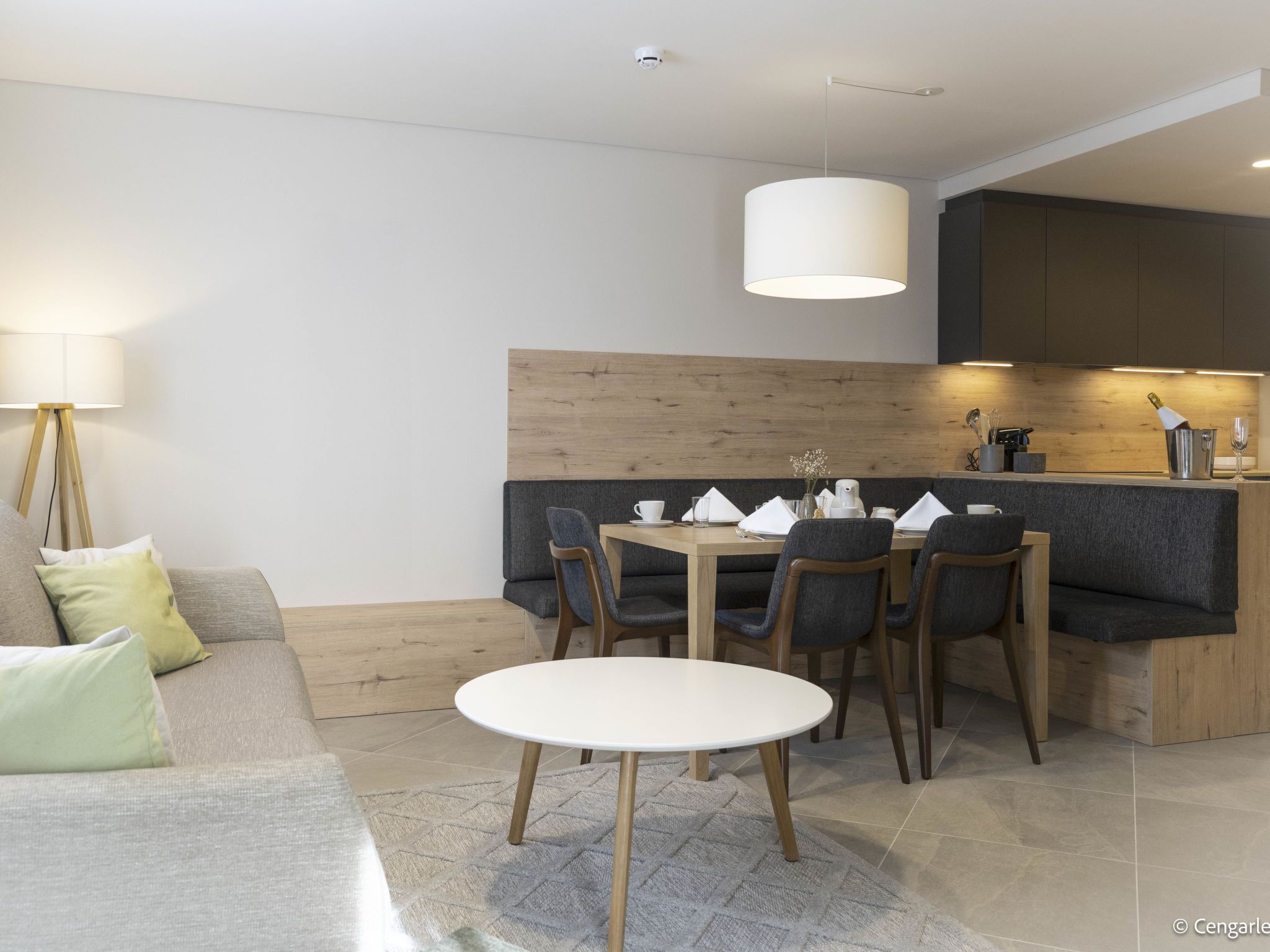 A modern dining area with a round table, chairs, and a bar counter.