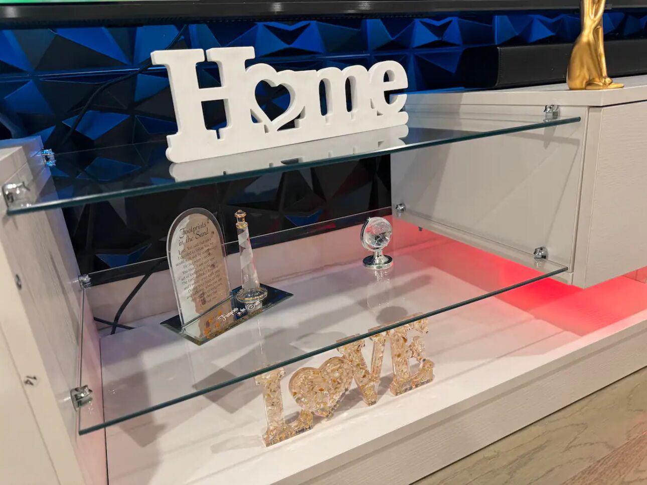 A display case with a 'Home' sign, a crystal trophy, and a 'LOVE' sign.