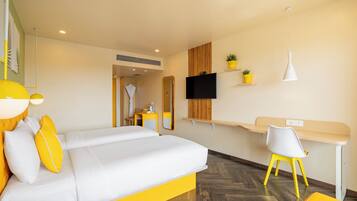 A modern hotel room with a bed, a desk, a chair, and a TV.