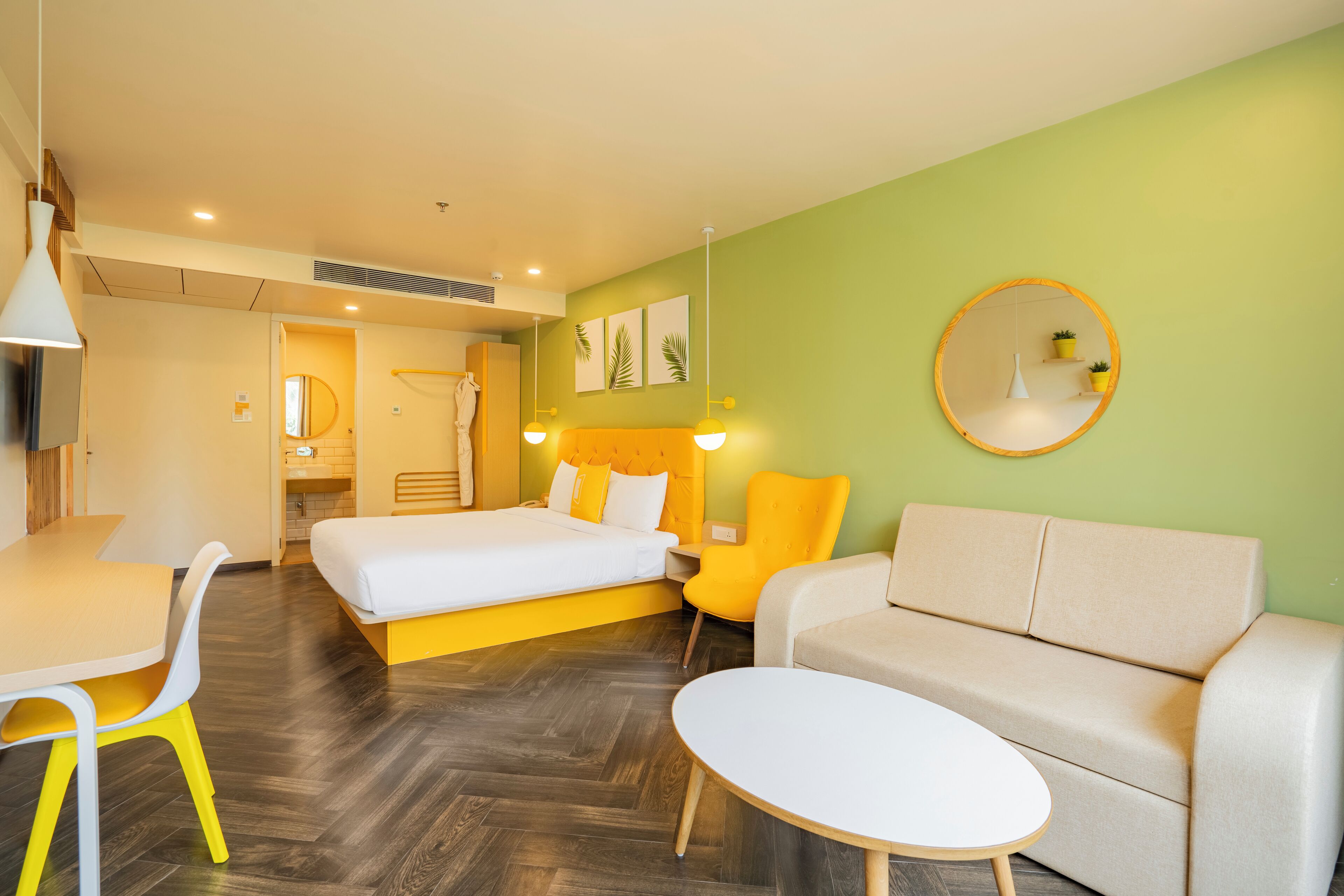 Une chambre d’hôtel moderne équipée d’un lit, d’un canapé, d’une table à manger et d’une petite table ronde.