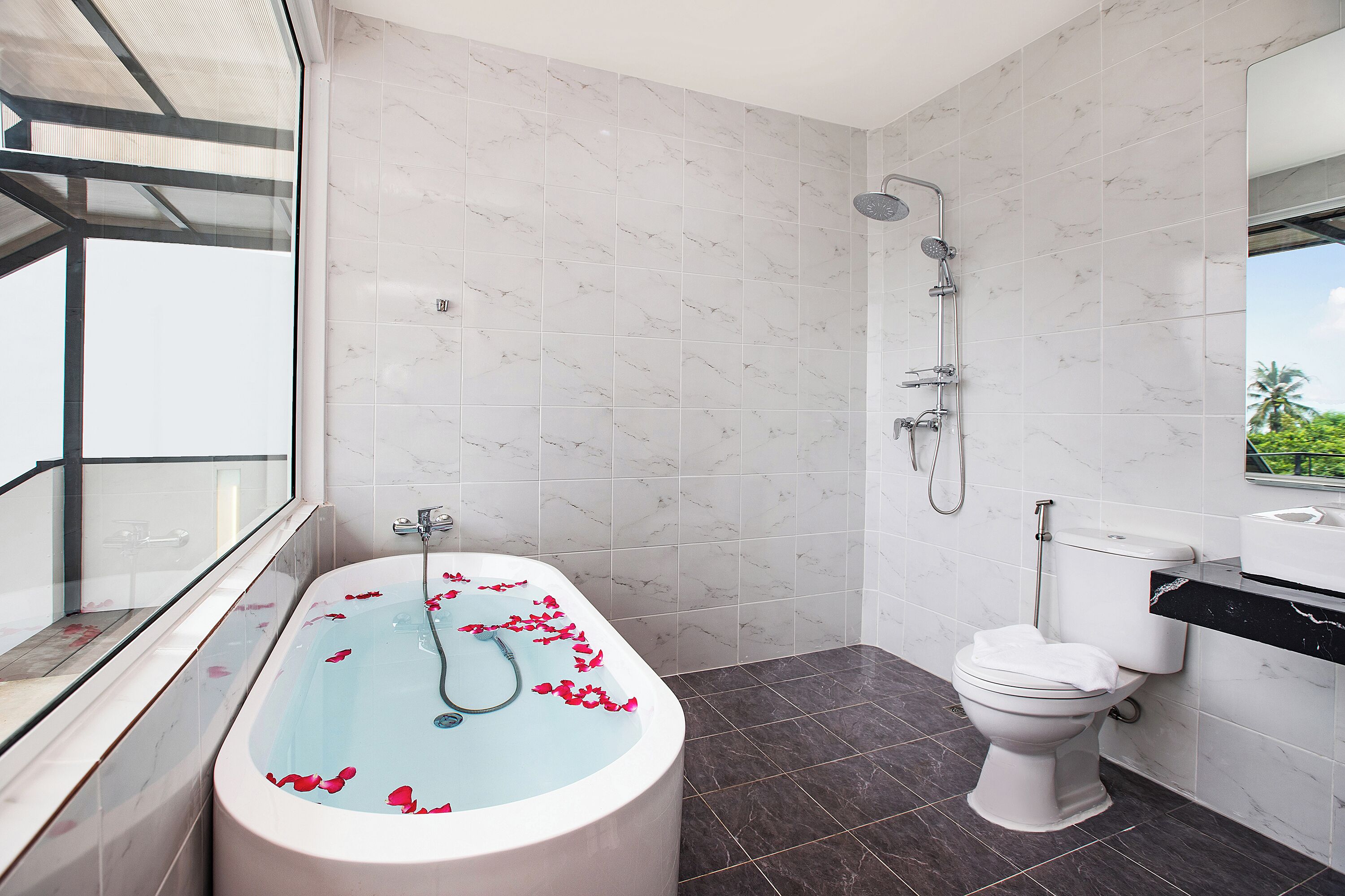 Une salle de bain moderne avec une baignoire sur pieds, une douche et des toilettes.