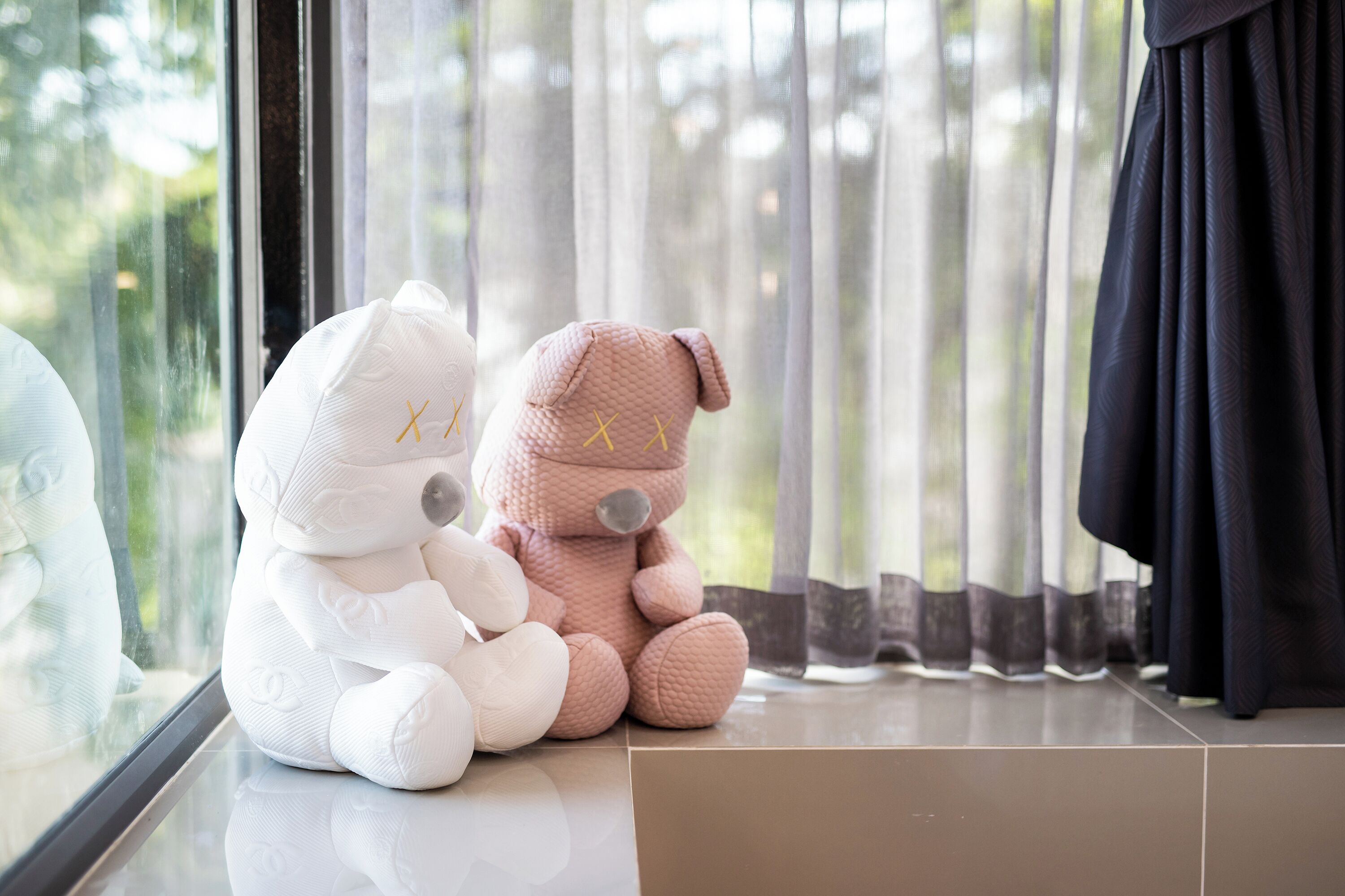 Two plush toys sitting on a windowsill.