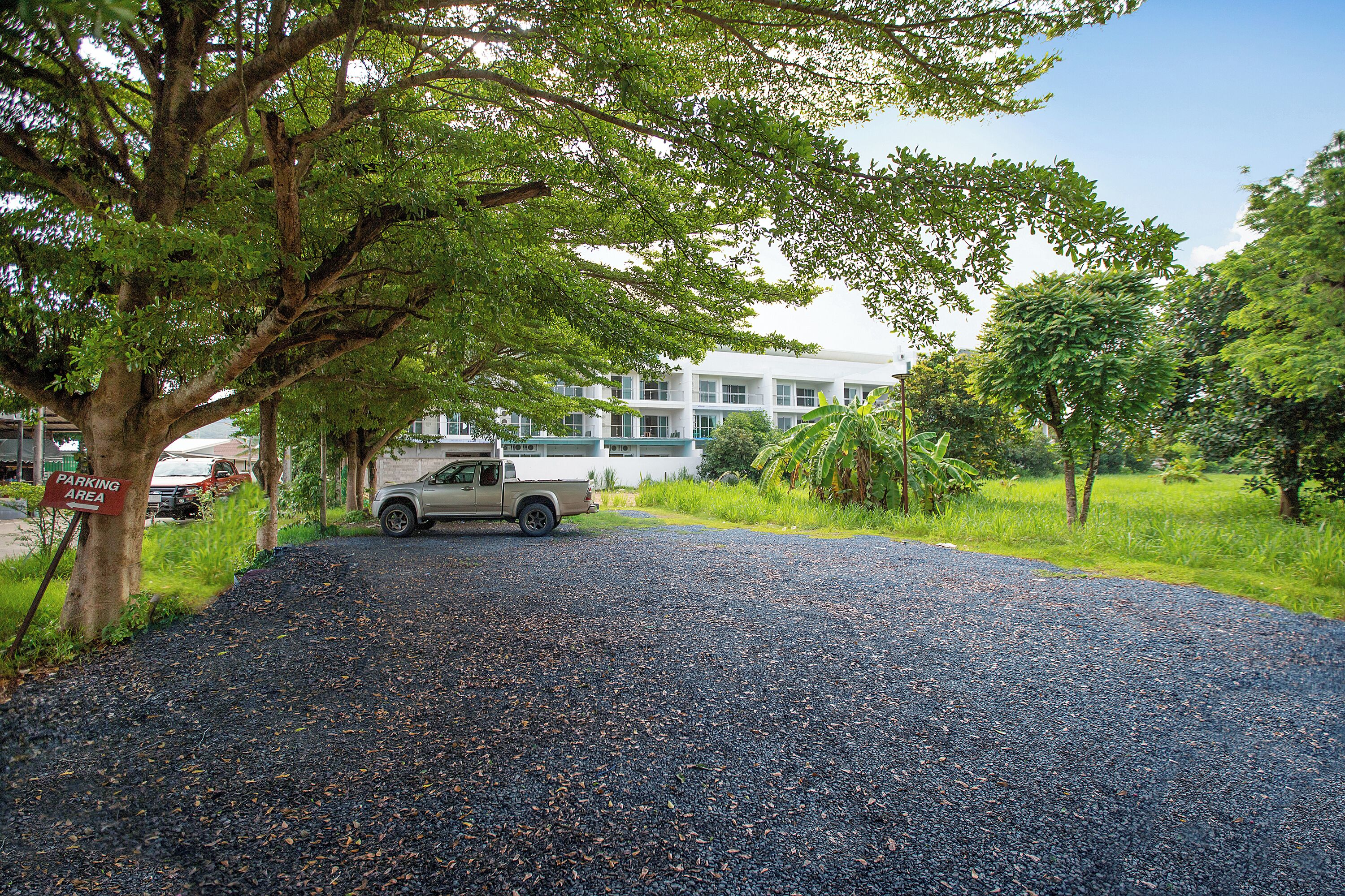 A gravel driveway leading to a building with a parked truck.