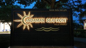 Segnaletica per Andaman Seafront Villa Phuket, con immagine di un sole e onde.