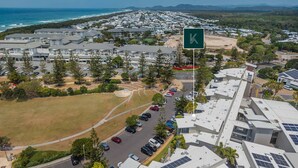 A residential area with modern houses, a parking lot, and a view of the ocean. - Resort Apartment 4304 at Bells Boulevard (Kingscliff)