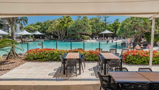 A poolside area with outdoor seating and a view of the pool. - Resort Apartment 4304 at Bells Boulevard (Kingscliff)