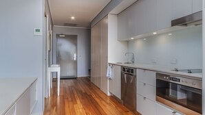A modern kitchen with stainless steel appliances, a dishwasher, and a built-in oven. - Resort Apartment 4304 at Bells Boulevard (Kingscliff)
