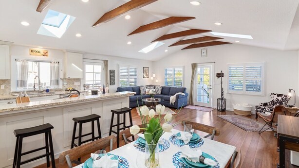 A spacious kitchen with a central island, a dining area with a table set for four, and a living area with a sofa and a coffee table. - Rooftop Retreat - Monterey House - Walk to the Monterey Aquarium (Monterey)