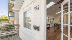 A white building with the number 787, a wooden deck, and a dining area with a table and chairs. - Rooftop Retreat - Monterey House - Walk to the Monterey Aquarium (Monterey)