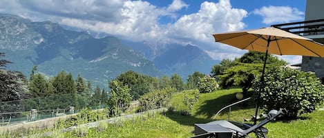 En uteplats med utemöbler och utsikt över bergen.