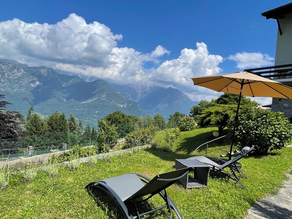 A patio with outdoor furniture and a mountain view.