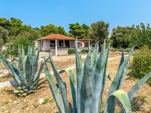A house with a red-tiled roof, surrounded by agave plants and trees. - Dundo House by Interhome (Rab/Kampor)