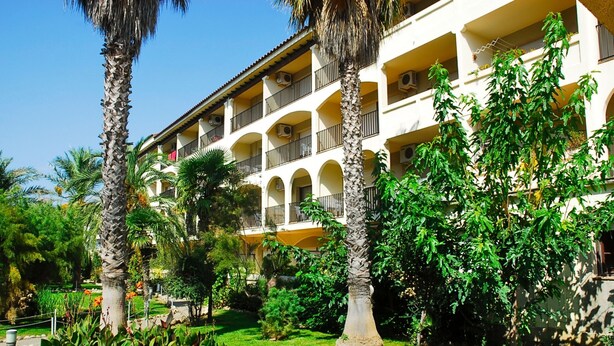 A multi-story hotel with balconies, surrounded by lush greenery and palm trees. - JARDINS DEL MAR 127 (Estartit)