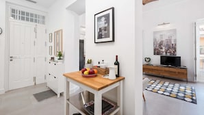 A modern living room with a wooden coffee table, a framed motivational quote, a cityscape painting, and a television on a wooden cabinet. - Solaga - Casapalma (Málaga)