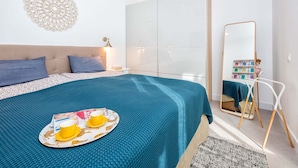 A modern bedroom with a large bed, a bedside table, a mirror, and a wardrobe. - Solaga - Casapalma (Málaga)