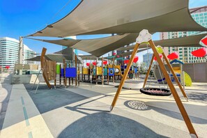 A playground with various play structures and a swing set. - Executive Studio MAG 318 (Dubai)