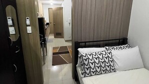 Hotellihuone, jossa on sänky, vaatekaappi ja kylpyhuone.