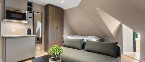 Un dormitorio moderno estilo loft con cama empotrada, kitchenette y zona de comedor.