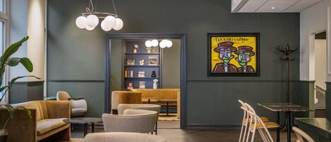 Un interior moderno con zonas de estar, una estantería y una obra de arte enmarcada en la pared.