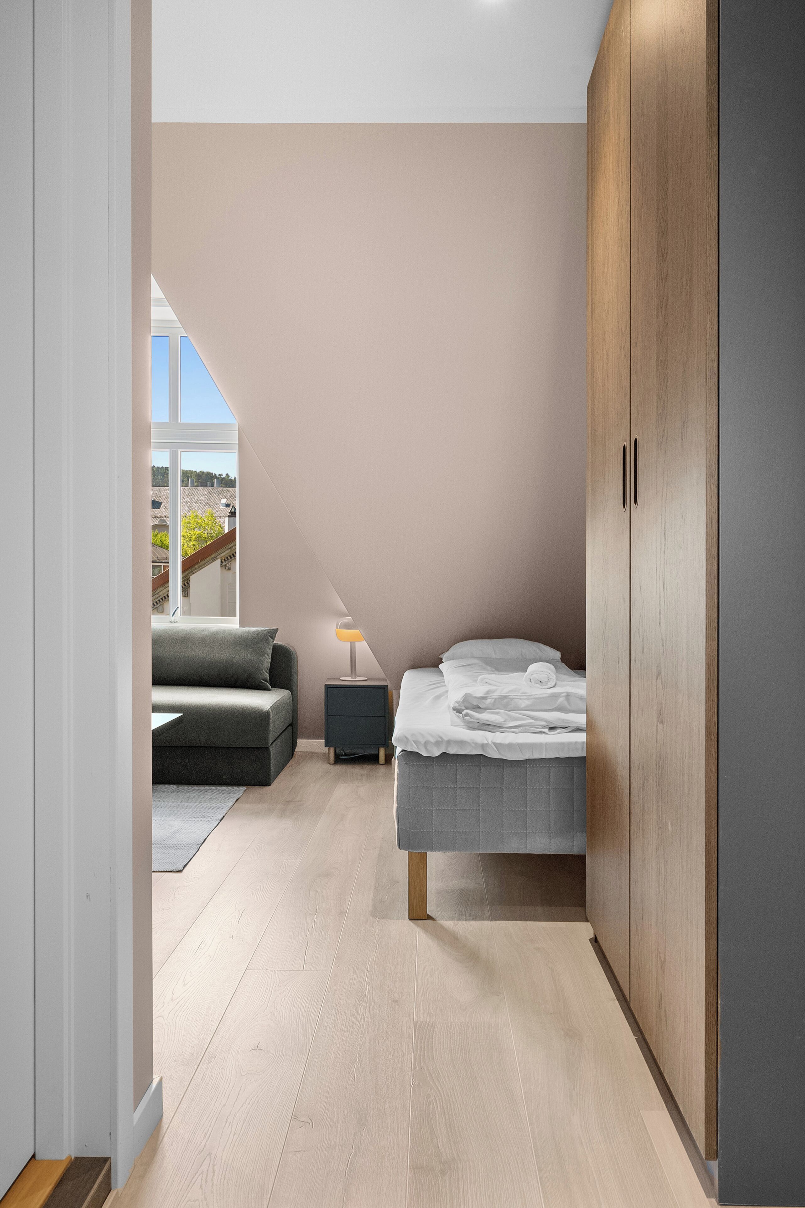 Ein Schlafzimmer mit Bett, Nachttisch, Sofa und Kleiderschrank.