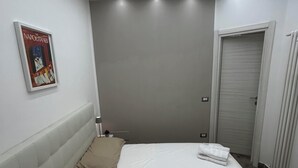 Una camera da letto moderna con un letto, una testiera, un poster appeso al muro e una porta.