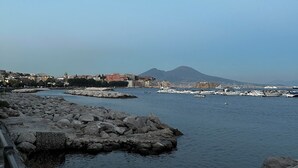 Una banchina rocciosa con barche e edifici sullo sfondo.