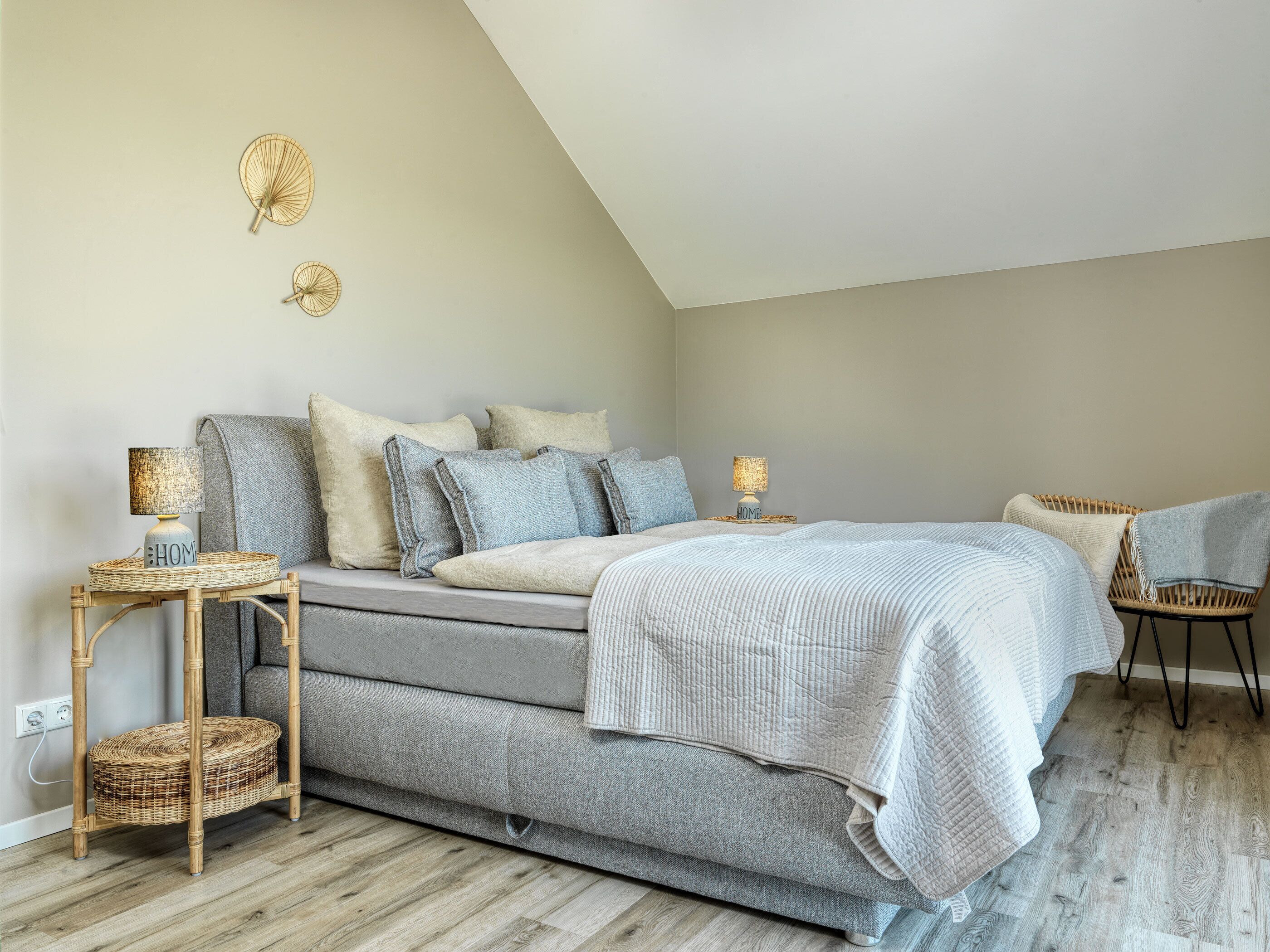 A bedroom with a bed, bedside tables, and a chair.
