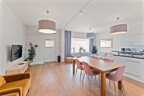 Moderni huoneisto, jossa on ruokailutila, keittiö ja oleskelutila.
