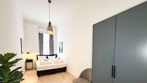 Un dormitorio moderno con cama, mesita de noche, lámpara y armario.