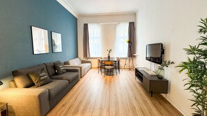 Una sala moderna con un sofá, una mesa de comedor y un televisor.