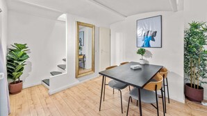 A modern dining area with a dark table, grey chairs, and a large mirror. - primeflats - Apartment Leberstr 58 Nr. 3 (Berlin)