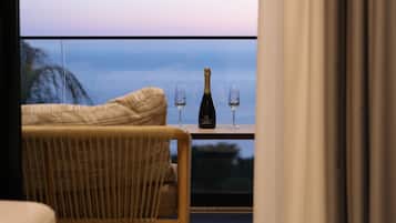 Relax and unwind on this serene balcony with a wicker chair and a table for a moment of peace.
