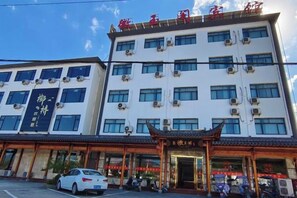 Un immeuble à plusieurs étages doté d’une entrée de style architectural chinois traditionnel et d’une enseigne.