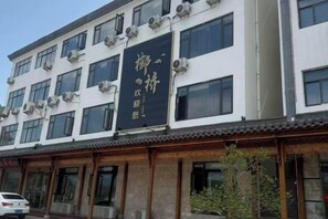 A building with multiple windows and air conditioning units. - Huiyuge Business Hotel, Luxian County (Jing County)