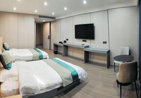 Una habitación de hotel con dos camas, televisión, escritorio y silla.