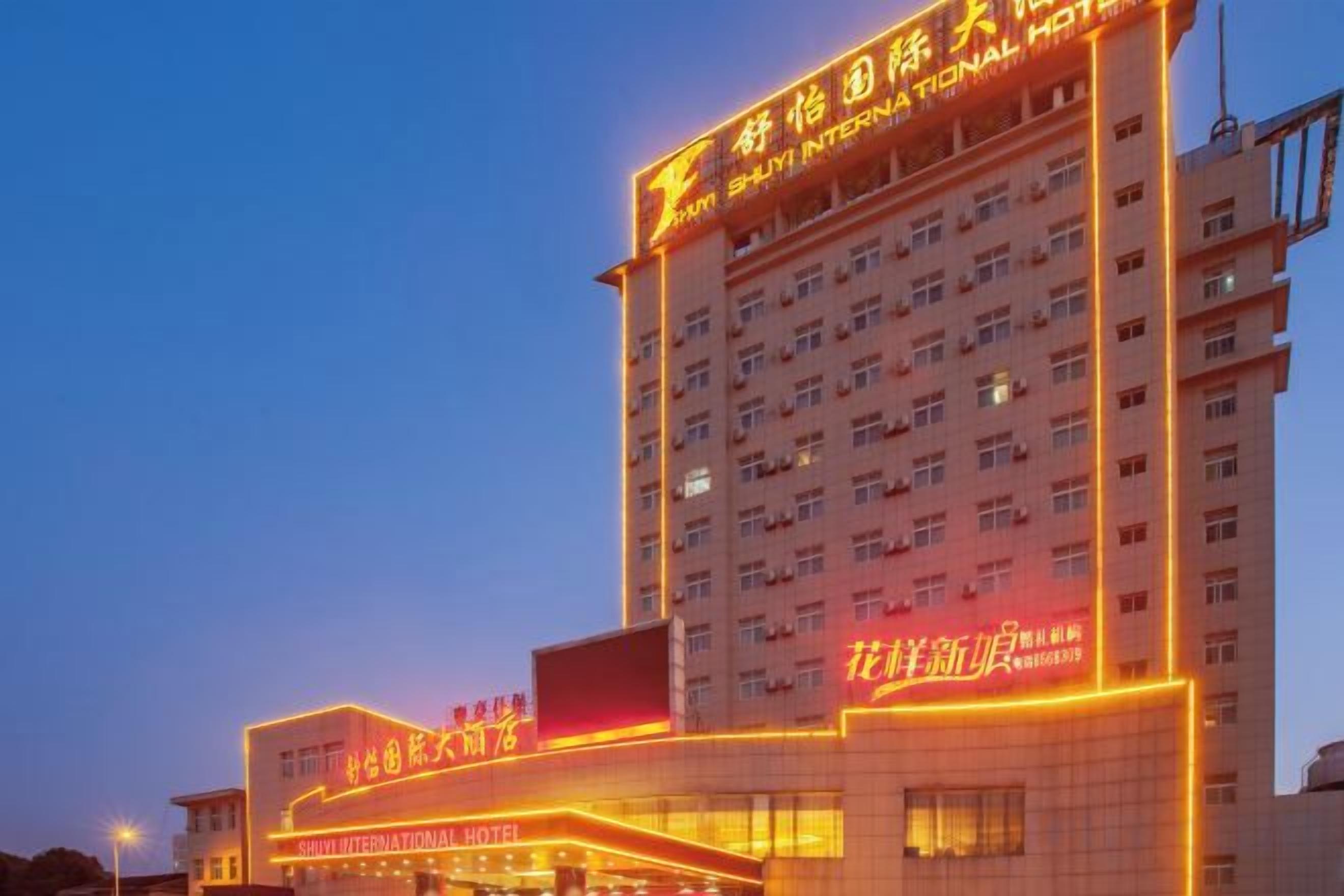 A multi-story hotel with illuminated signage and a prominent entrance.