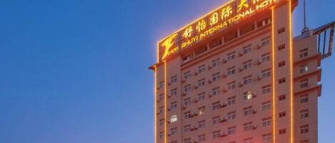 A multi-story hotel with illuminated signage and a prominent entrance.