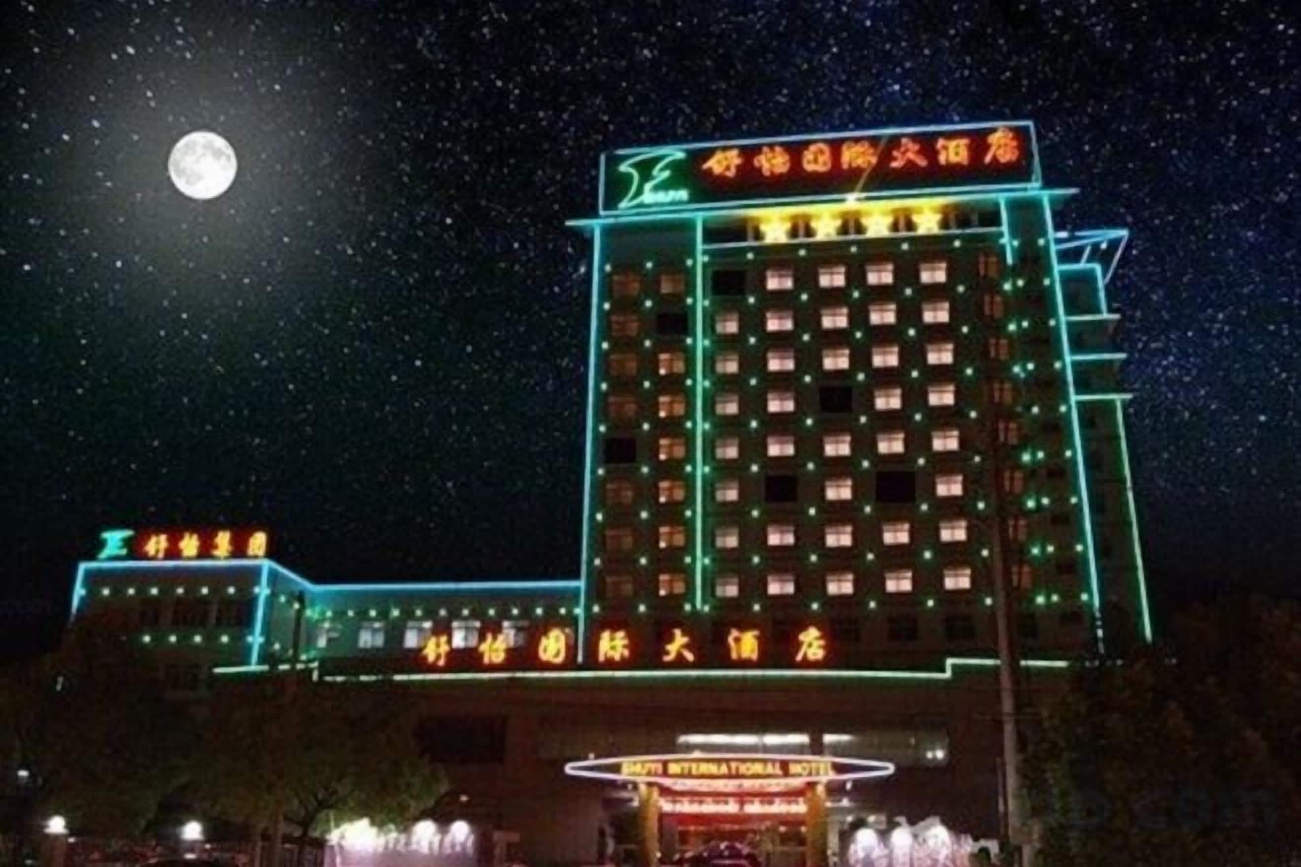 A multi-story hotel with illuminated signage and a prominent entrance.